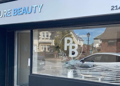 Exterior view of Pure Beauty, Holytown, Scotland, GB, showcasing its stylish signage and welcoming entrance.