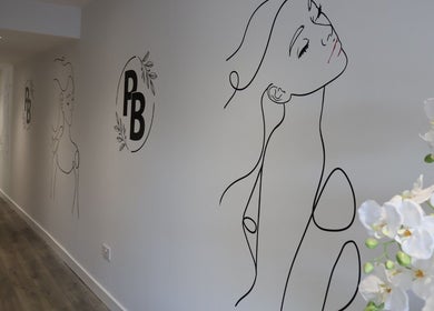 Artistic wall decor at Pure Beauty, Holytown, Scotland, GB featuring elegant line art and floral accents.
