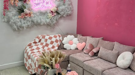 Chic pink-themed lounge at Rhilaxandrhivive, Barnsley, England, GB with plush décor and wall art.