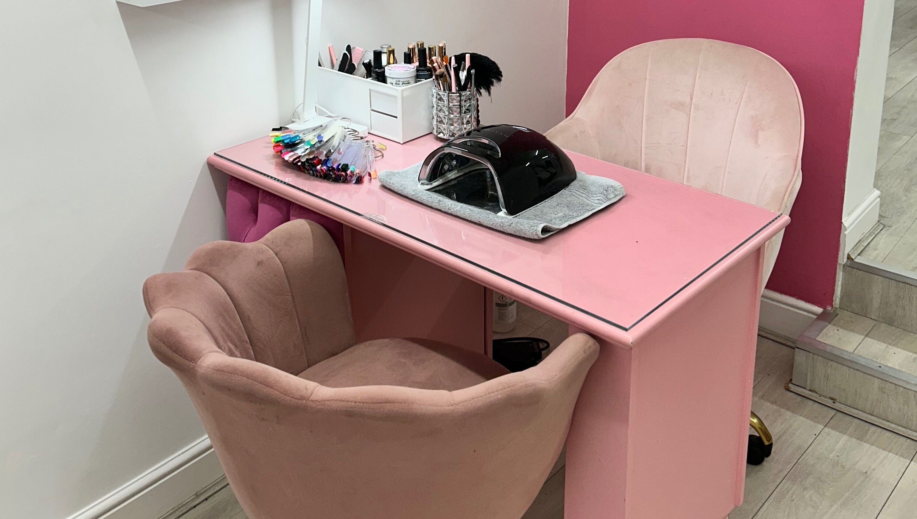 Pink nail station at Rhilaxandrhivive in Barnsley, England, GB with manicure tools and plush chairs.