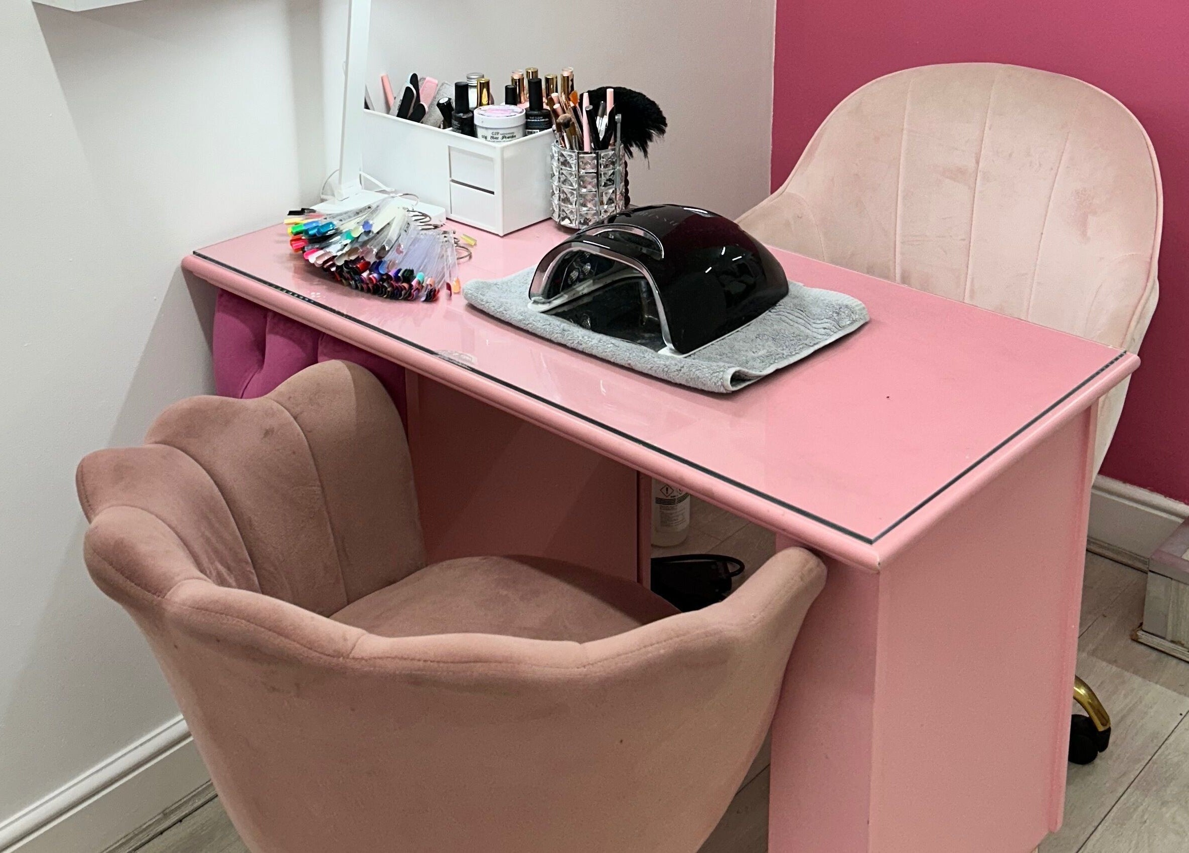Pink nail station at Rhilaxandrhivive in Barnsley, England, GB with manicure tools and plush chairs.