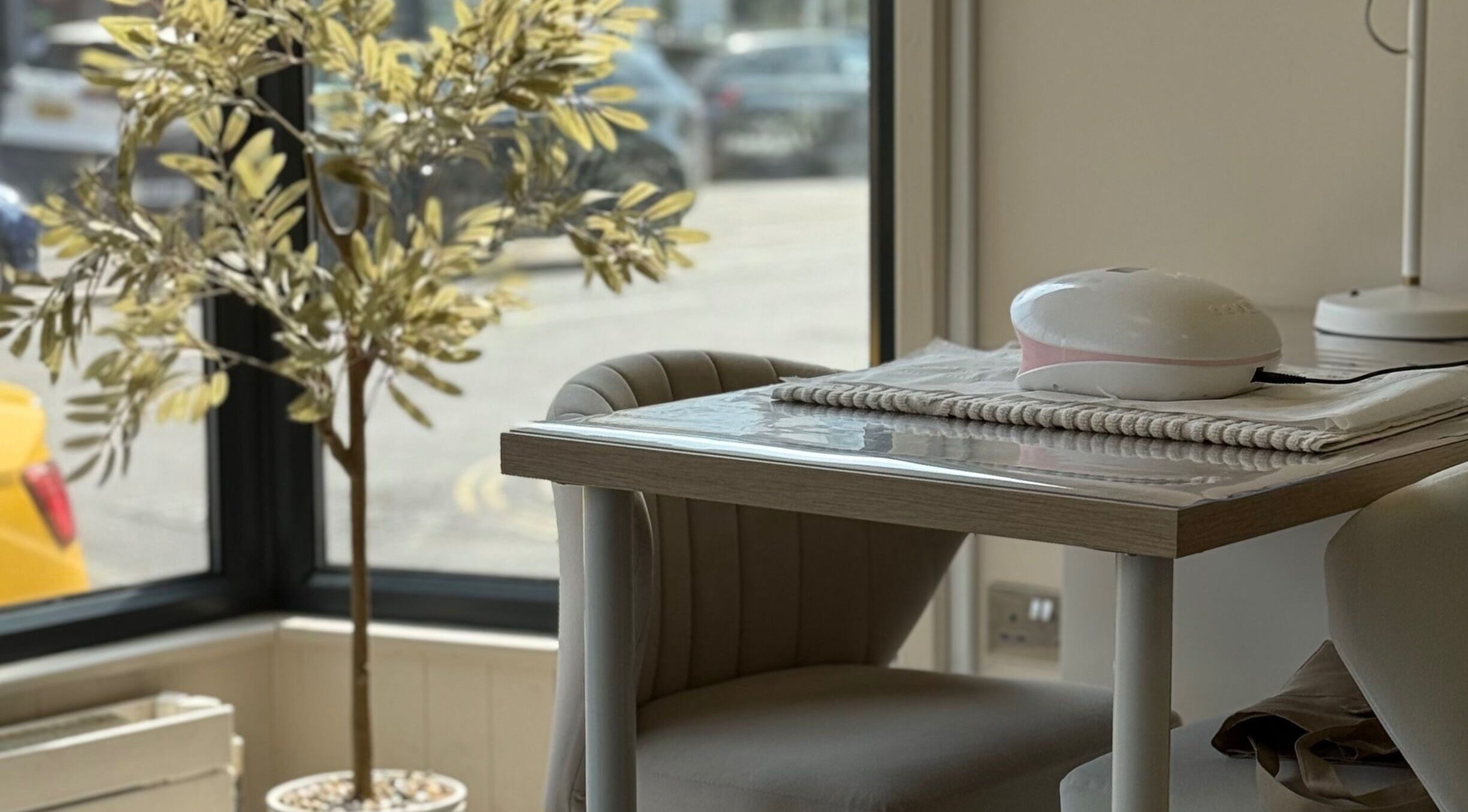 Cozy seating at Sorelle Beauty House, Lytham St Annes, England, GB with decorative plant and nail table.
