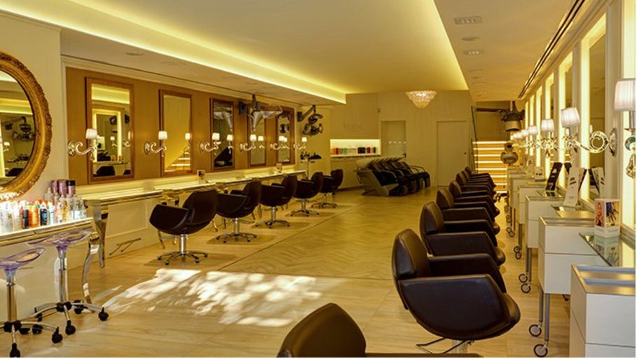 Interior de Francisco Peluqueros en Palma, Illes Balears, ES con modernos asientos y espejos iluminados.