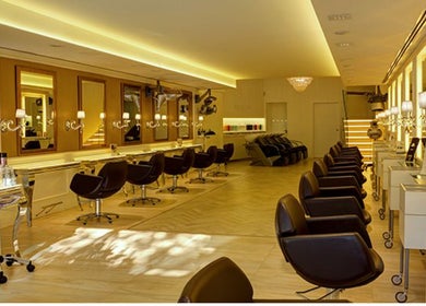 Interior de Francisco Peluqueros en Palma, Illes Balears, ES con modernos asientos y espejos iluminados.