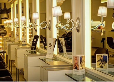 Interior de Francisco Peluqueros en Palma, Illes Balears, ES, mostrando estaciones de estilismo iluminadas.