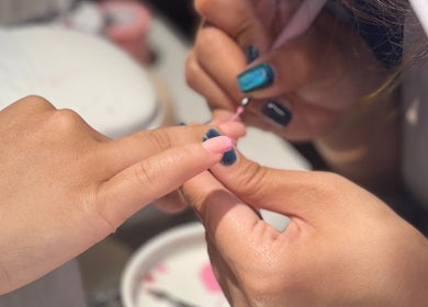 Nail artist creating a pink manicure at NǐĦǎo Pisces Nails Hair Beauty唐人美发 in L-imsida, MT.