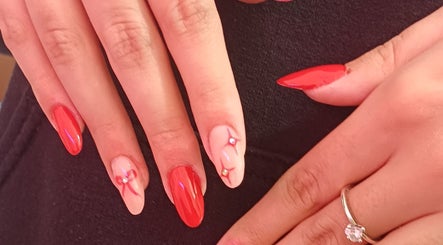 Elegante rote und rosa Nageldesigns mit Schmucksteinen bei NailBar Visp, Visp, Wallis, CH.