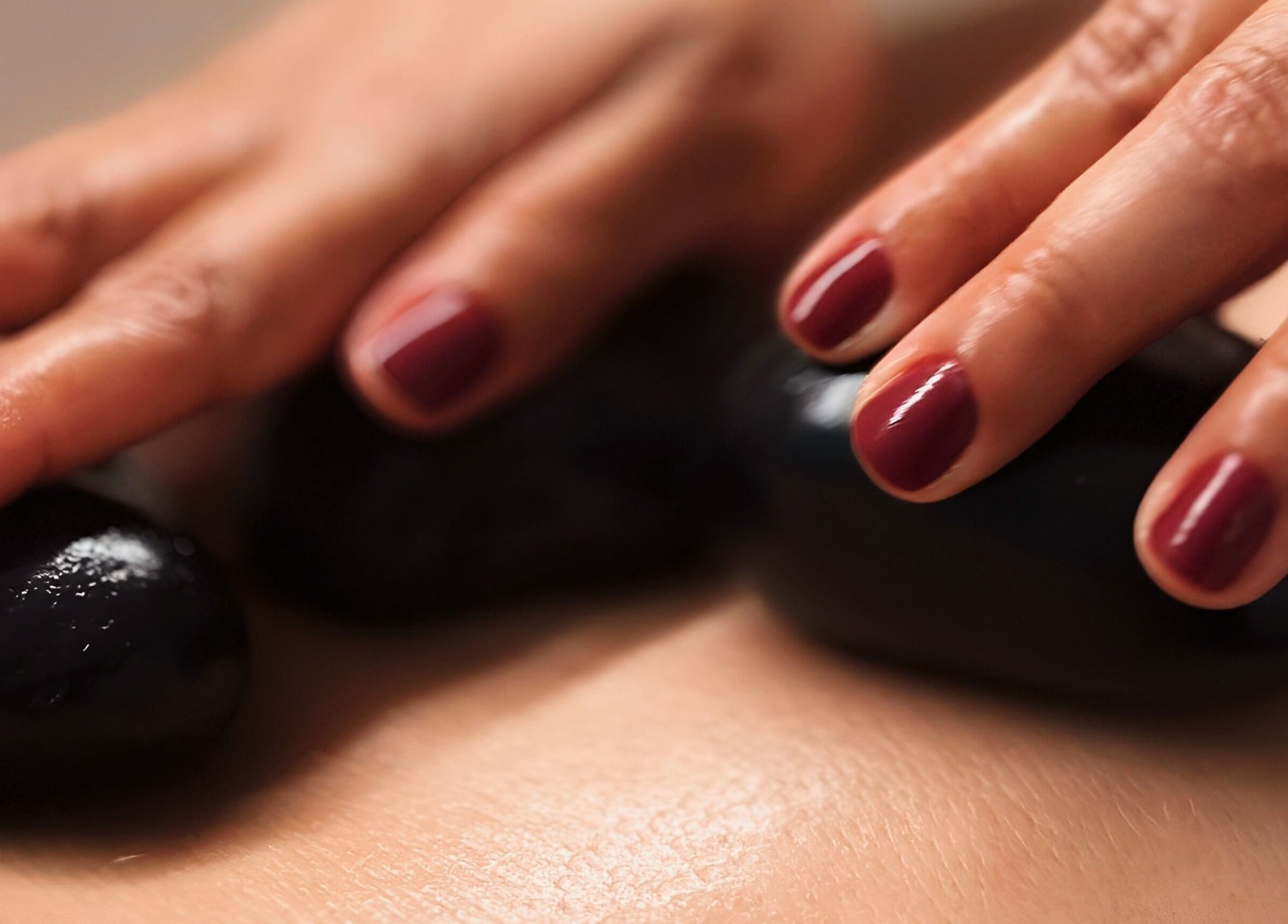 Pedras quentes em massagem no Positive Hands, Quarteira, Faro, PT, criando uma experiência relaxante.