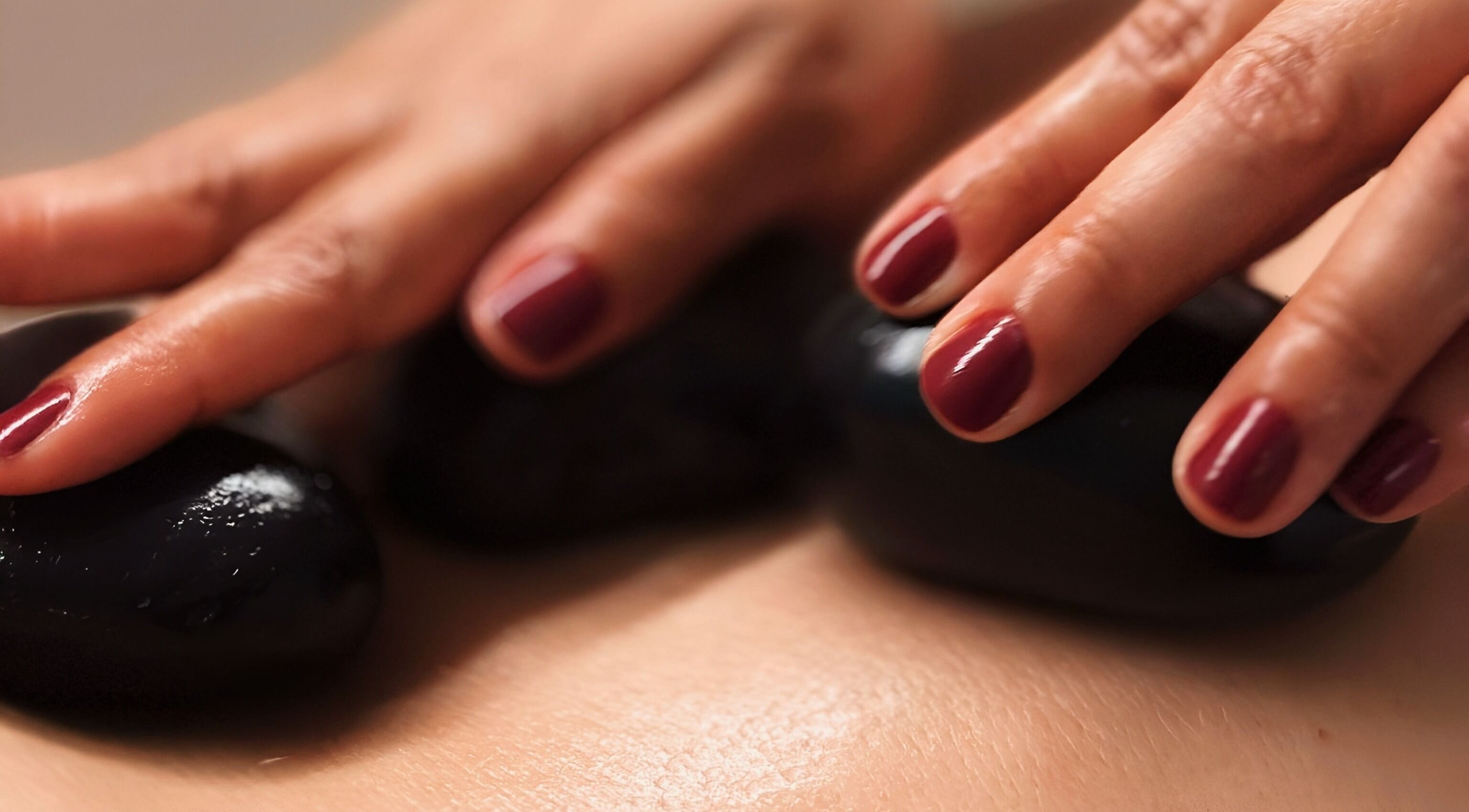 Pedras quentes em massagem no Positive Hands, Quarteira, Faro, PT, criando uma experiência relaxante.