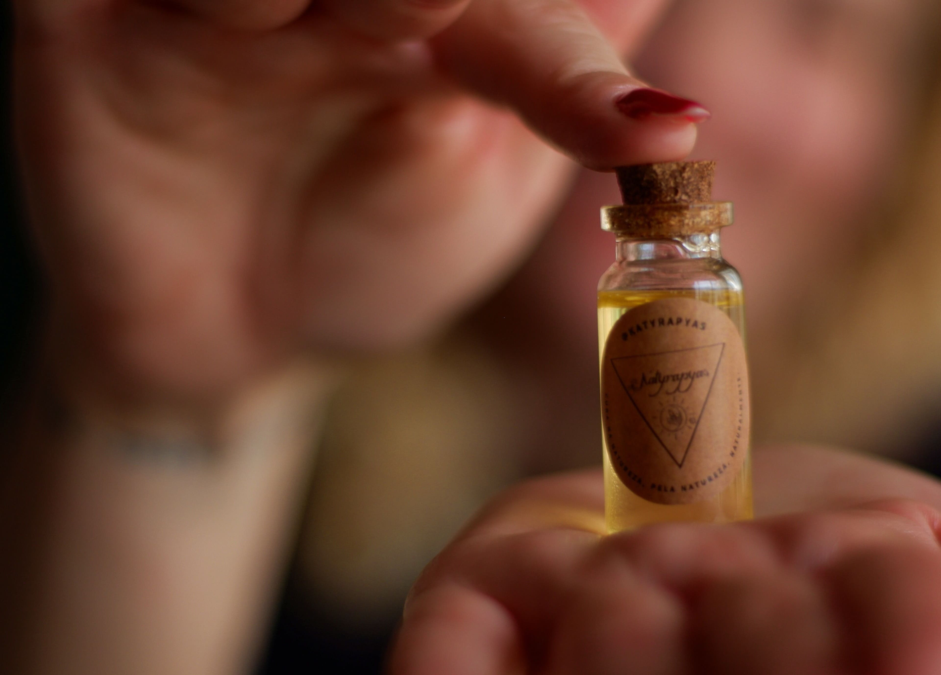 Pequeno frasco de óleo essencial na mão em Positive Hands, Quarteira, Faro, PT.