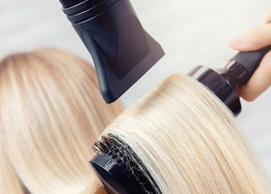 Professional blowout at Blo Me Ou', Blow Dry Bar, Jacksonville, Florida, US enhances sleek hair finish.