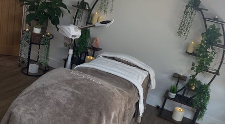 Serene therapy room at Varches Skin & Body Studio, Meopham, England, GB showcasing a massage bed and lush greenery.