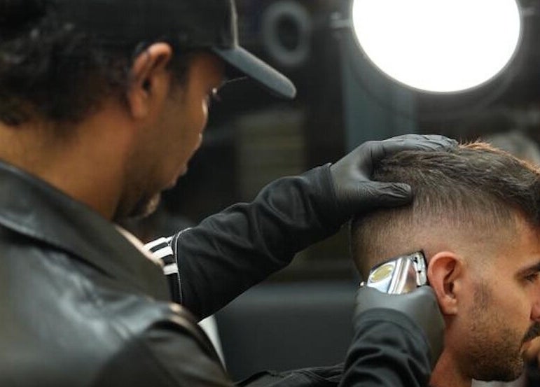 Barber giving a haircut at Dialan Gents Salon L.L.C, Dubai, AE. Professional grooming services shown.
