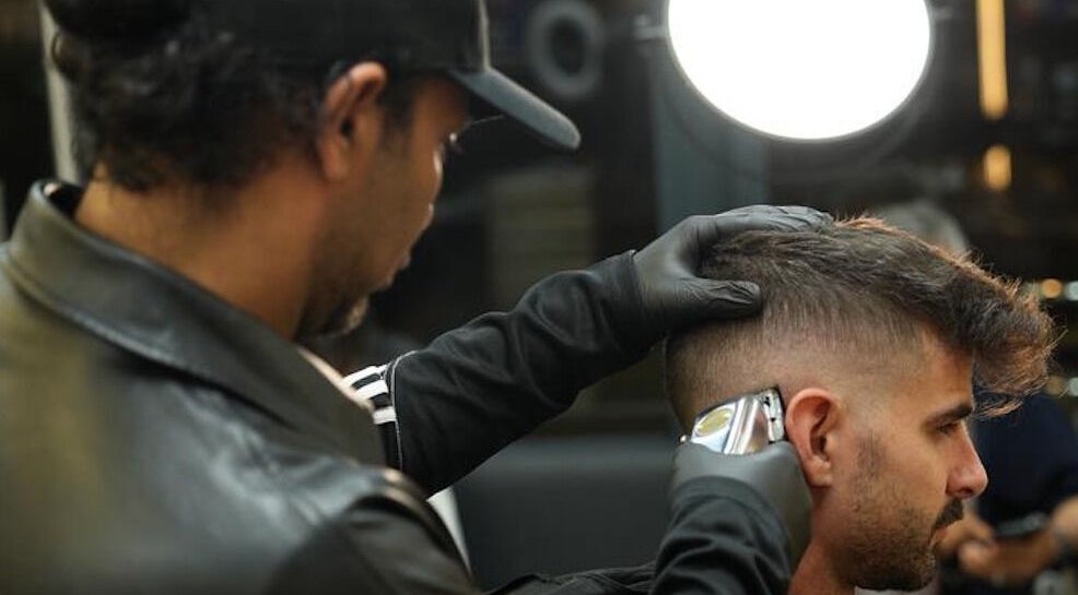 Barber giving a haircut at Dialan Gents Salon L.L.C, Dubai, AE. Professional grooming services shown.