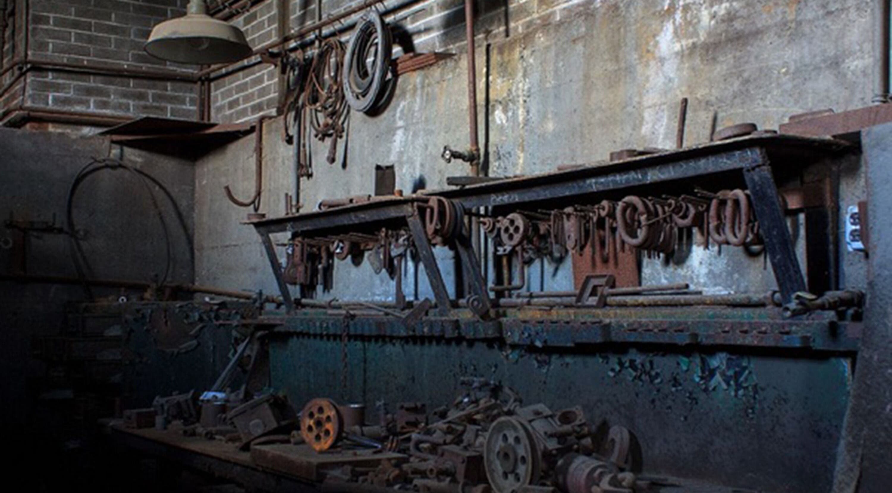 Rustic industrial workshop interior at Sadalako, T'bilisi, GE, featuring vintage tools and machinery.