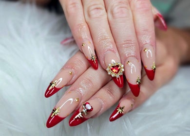 Stunning red-tipped nails with gold accents at Dark Envy Nails, Swaffham, England, GB showcasing elegance.