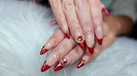 Stunning red-tipped nails with gold accents at Dark Envy Nails, Swaffham, England, GB showcasing elegance.