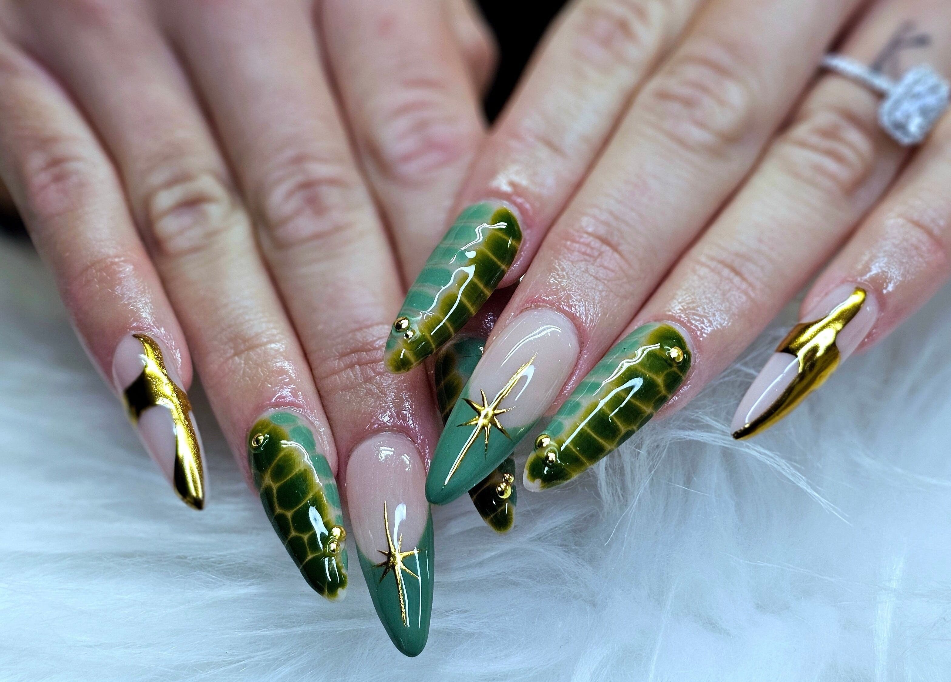Stunning green and gold nail art by Dark Envy Nails in Swaffham, England, GB on a fluffy white surface.