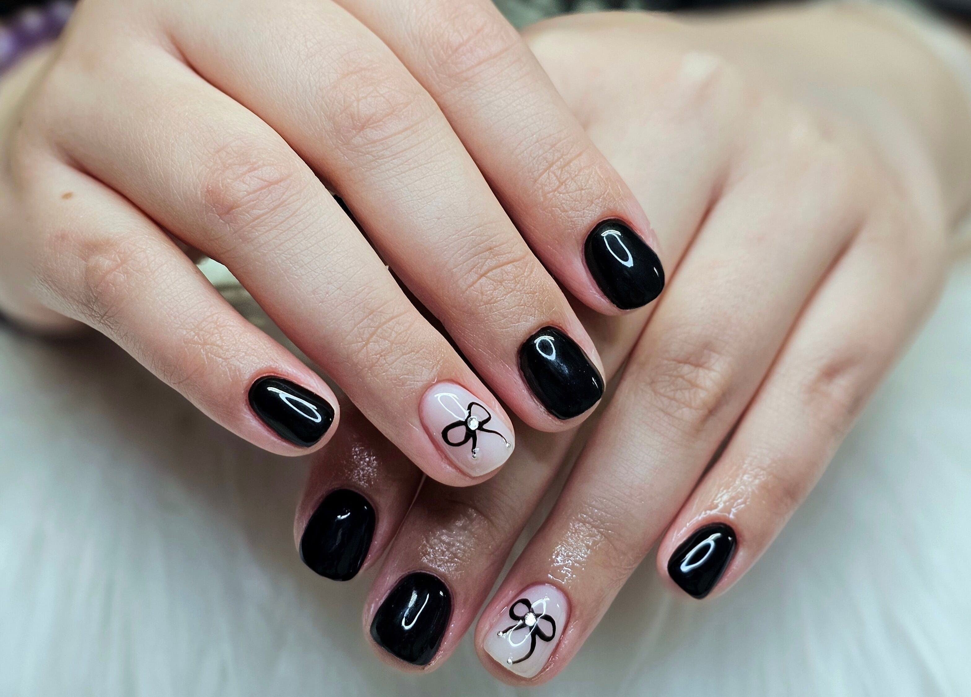 Elegant black manicured nails with bow art at Dark Envy Nails, Swaffham, England, GB.