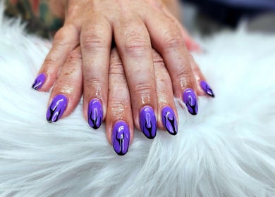 Stylish purple flame nails at Dark Envy Nails, Swaffham, England, GB, on a soft white fur background.