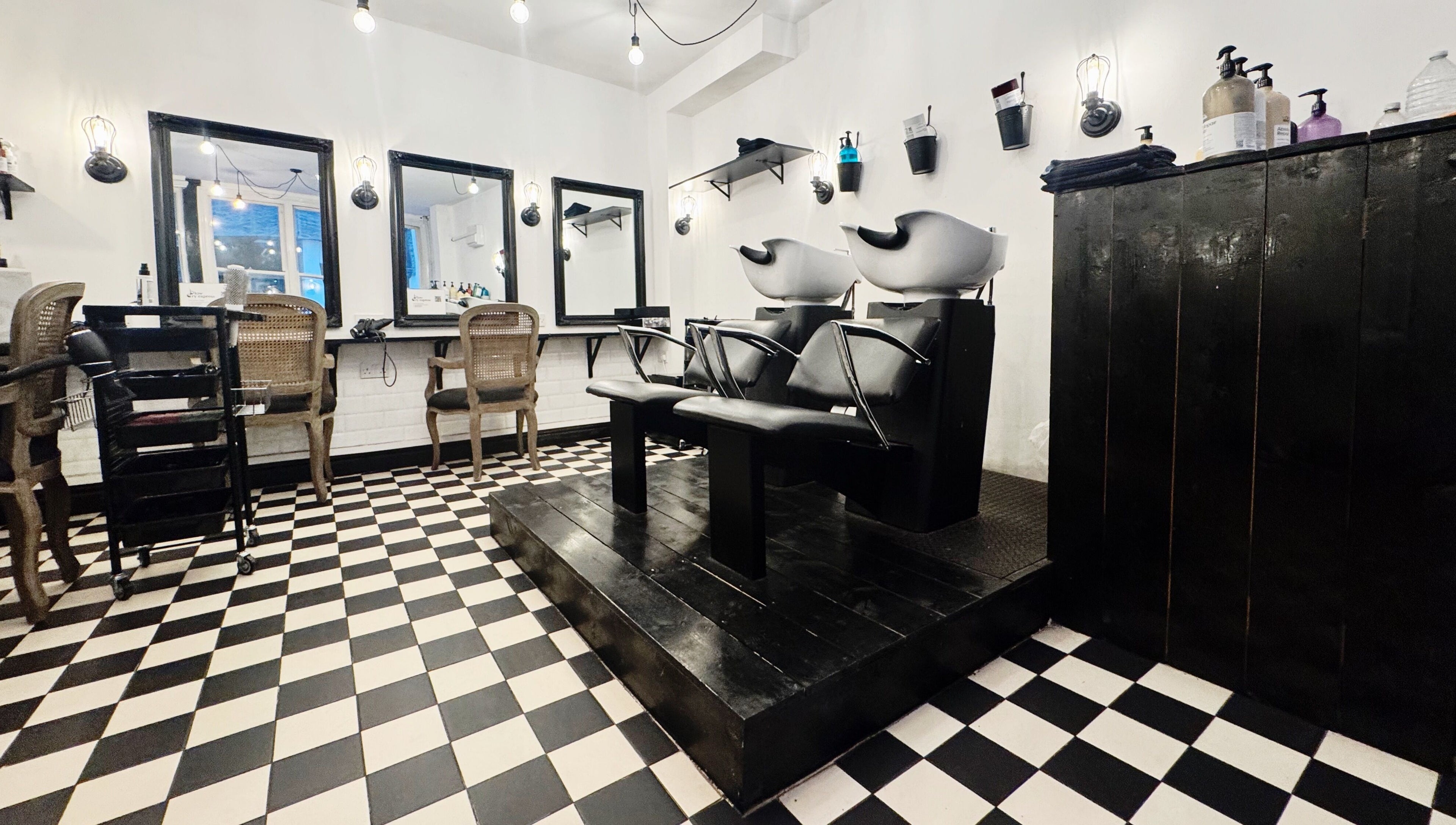 Elegant salon interior at Blow Dry Express - Monument in London, United Kingdom, GB with stylish chairs and mirrors.