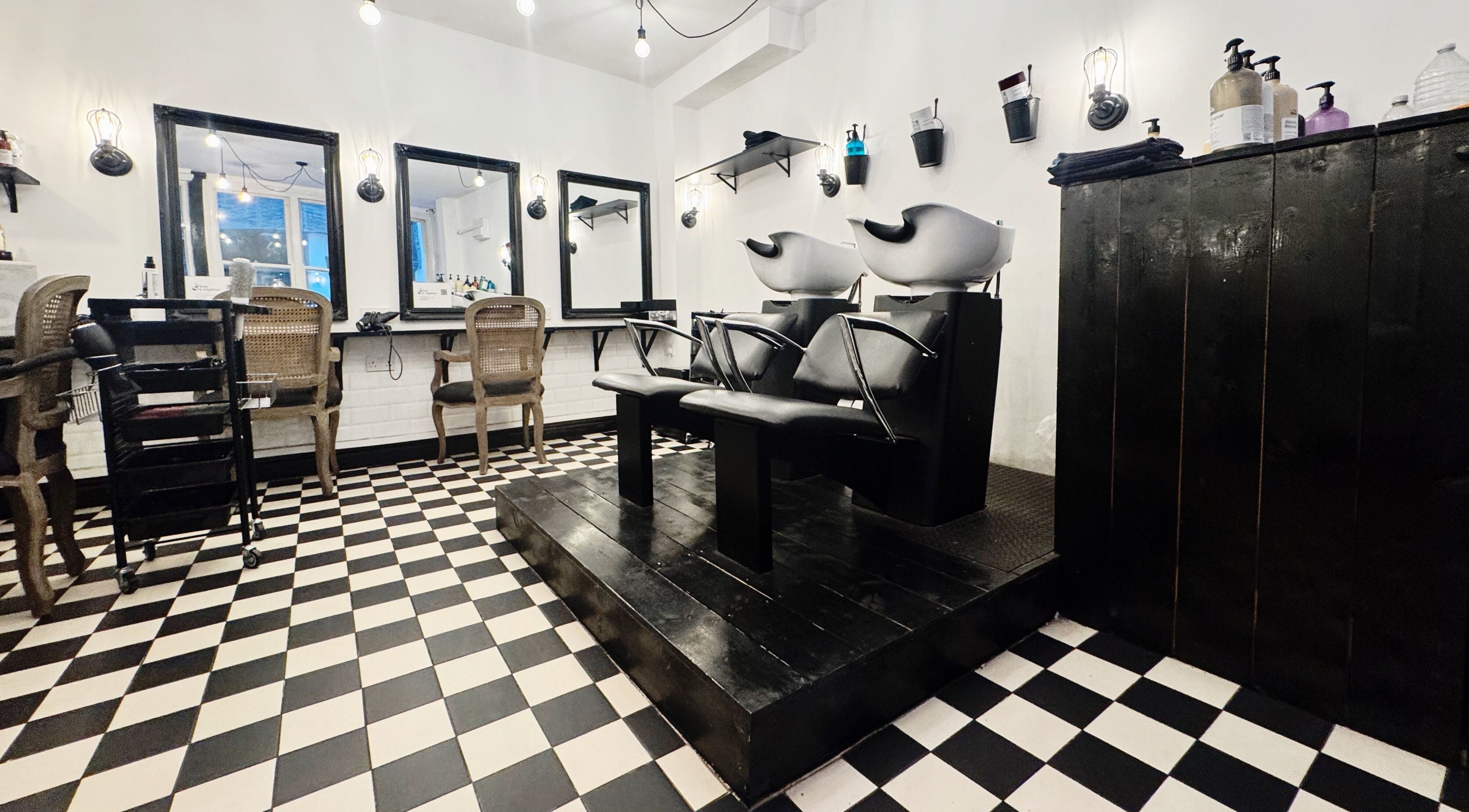 Elegant salon interior at Blow Dry Express - Monument in London, United Kingdom, GB with stylish chairs and mirrors.
