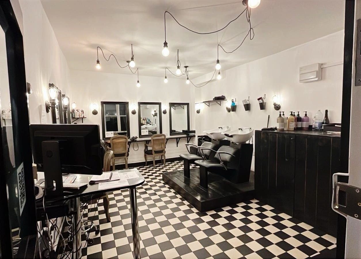 Stylish salon interior at Blow Dry Express - Monument, London, United Kingdom, GB with modern decor and workstations.