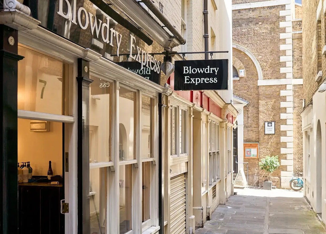 View of Blow Dry Express - Monument in London, United Kingdom, GB along a charming alleyway.
