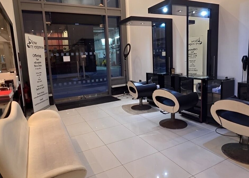 Modern salon interior at Blow Dry Express - St Pauls, London, United Kingdom, GB with stylish chairs and mirrors.
