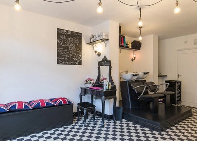 Elegant interior of Blow Dry Express - Liverpool Street, London with black and white decor and styling stations.