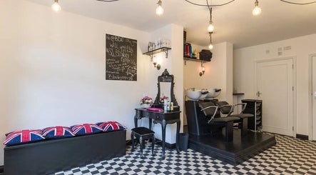 Elegant interior of Blow Dry Express - Liverpool Street, London with black and white decor and styling stations.