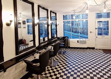 Stylish salon at Blow Dry Express - Liverpool Street, London, United Kingdom, GB with checkered floors and mirrors.