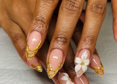 Intricate gold and floral nail art at Gloow Nails, Randburg, Gauteng, ZA, showcasing elegant hand detailing.