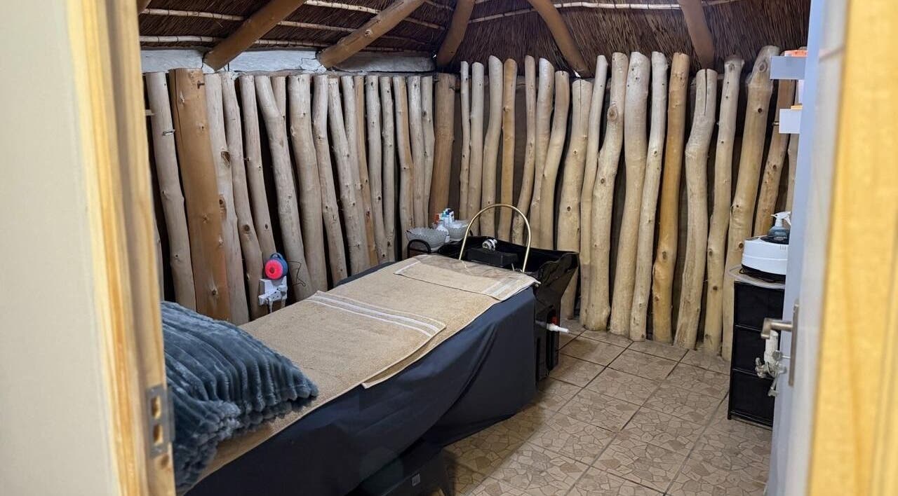 Cozy massage room at Tiara's Beauty Spa in Cape Town, Western Cape, ZA with rustic wooden decor and a massage table.