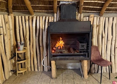 Rustic fireplace and chair at Tiara's Beauty Spa, Cape Town, Western Cape, ZA create a warm ambiance.