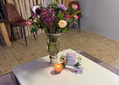 Vase with vibrant flowers and candle at Tiara's Beauty Spa, Cape Town, Western Cape, ZA.