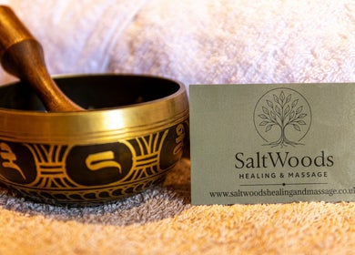 Singing bowl and Saltwoods Healing & Massage card in Herne Bay, England, GB on a towel.