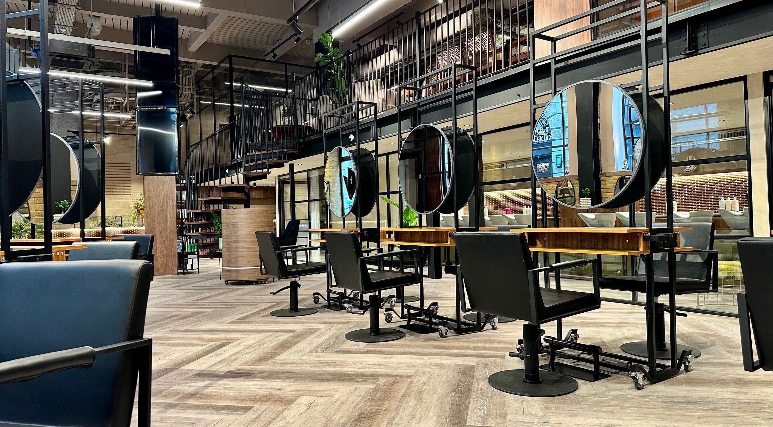 Modern salon at Peter William Hair in London, England, GB, featuring sleek styling stations and mirrors.