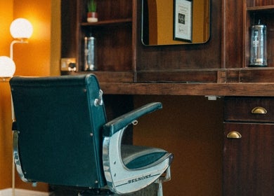 Vintage barber chair at Loveday's Barber Shop in Sheffield, England, GB with warm decor and stylish mirror.