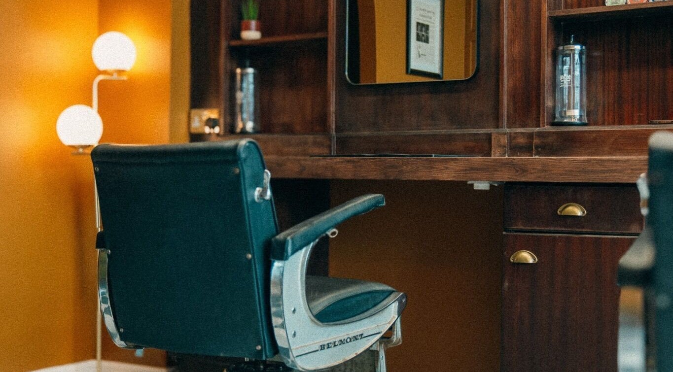 Vintage barber chair at Loveday's Barber Shop in Sheffield, England, GB with warm decor and stylish mirror.