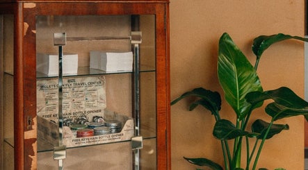 Classic wooden display cabinet at Loveday's Barber Shop, Sheffield, England, GB, showcasing grooming products.
