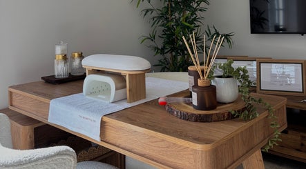 Elegant spa desk setup at AmiRoseBeauté, Barrington, England, GB, featuring natural decor and wellness items.