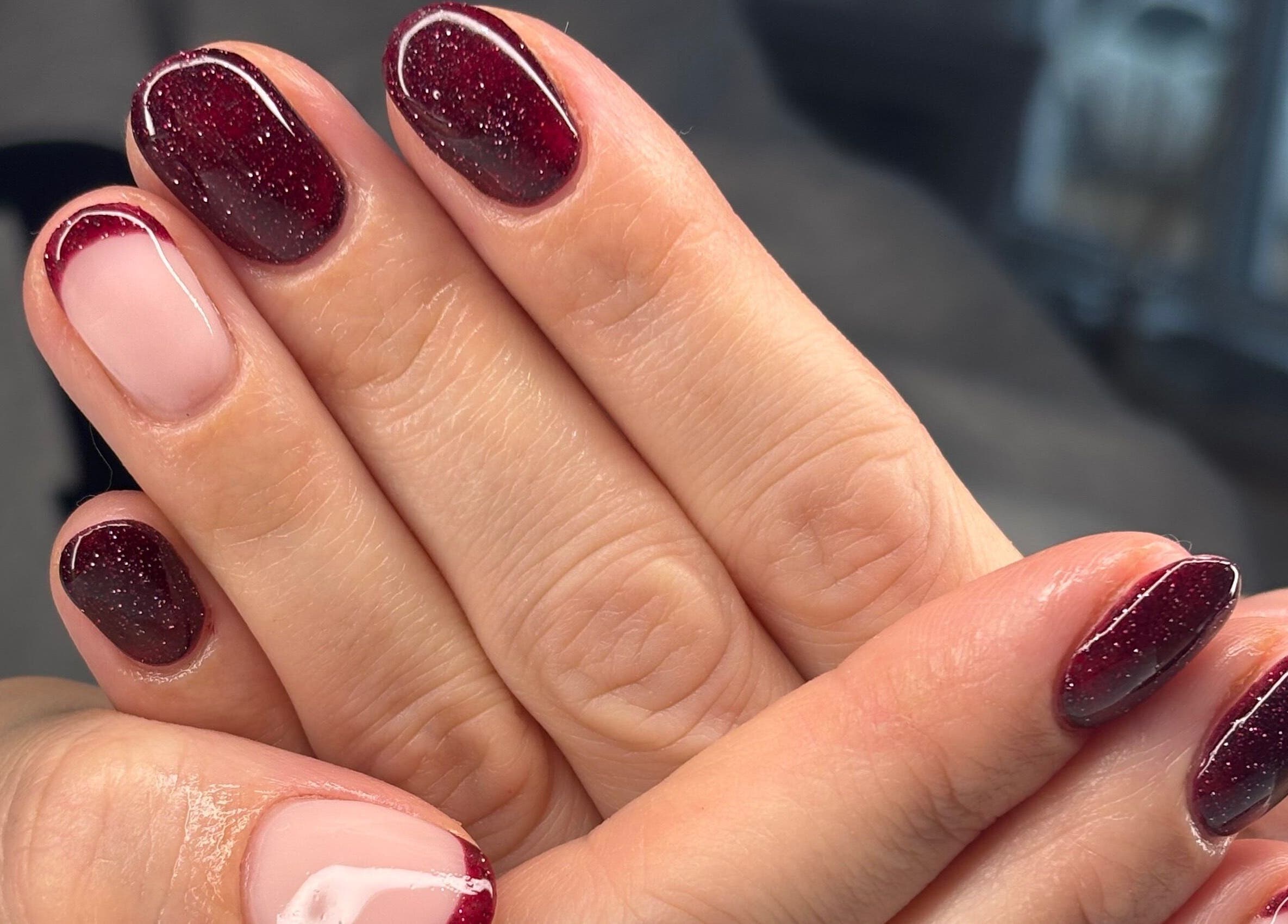 Elegant garnet manicure at AmiRoseBeauté, Barrington, England, GB. Featuring glossy, deep red, sparkling nails.