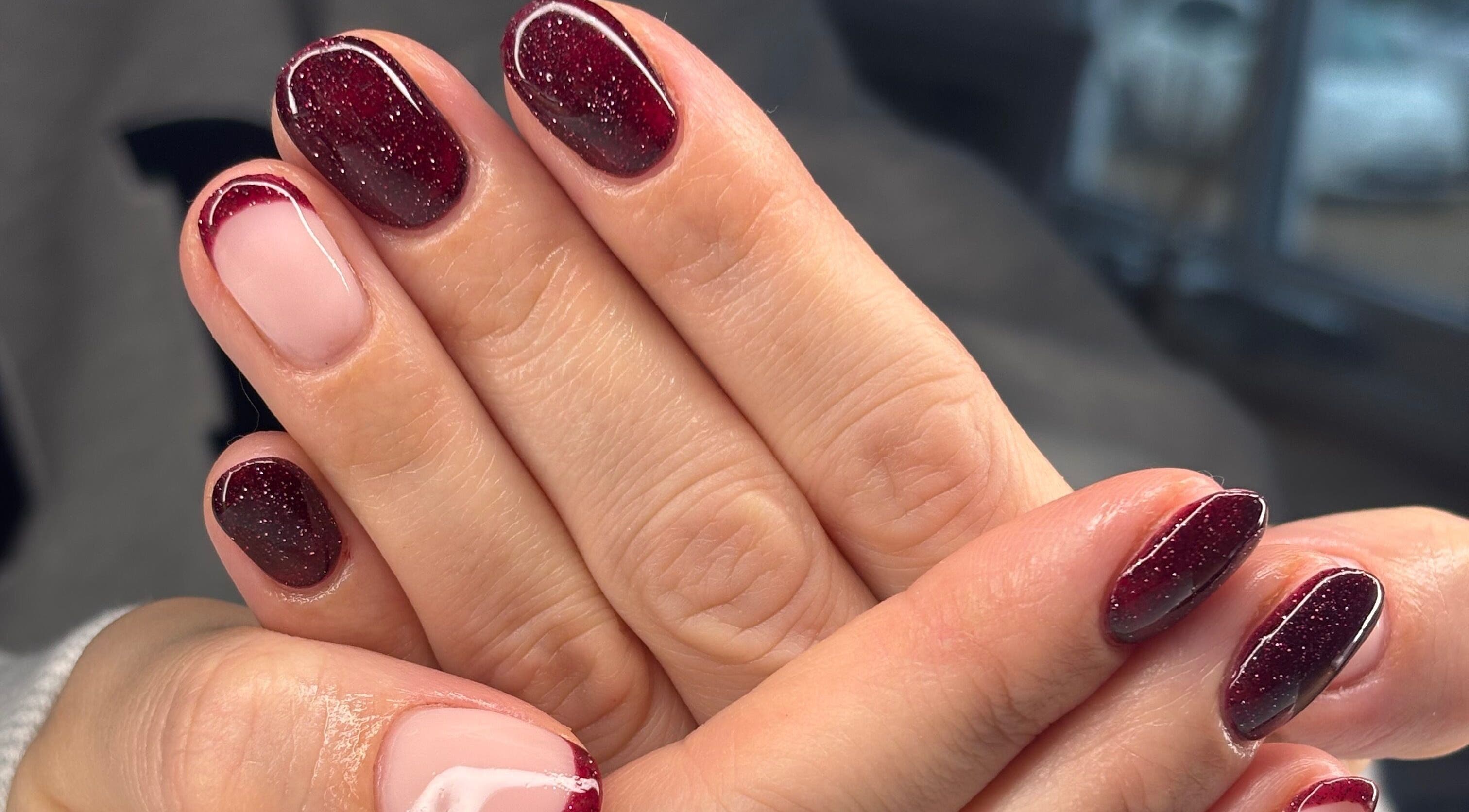 Elegant garnet manicure at AmiRoseBeauté, Barrington, England, GB. Featuring glossy, deep red, sparkling nails.
