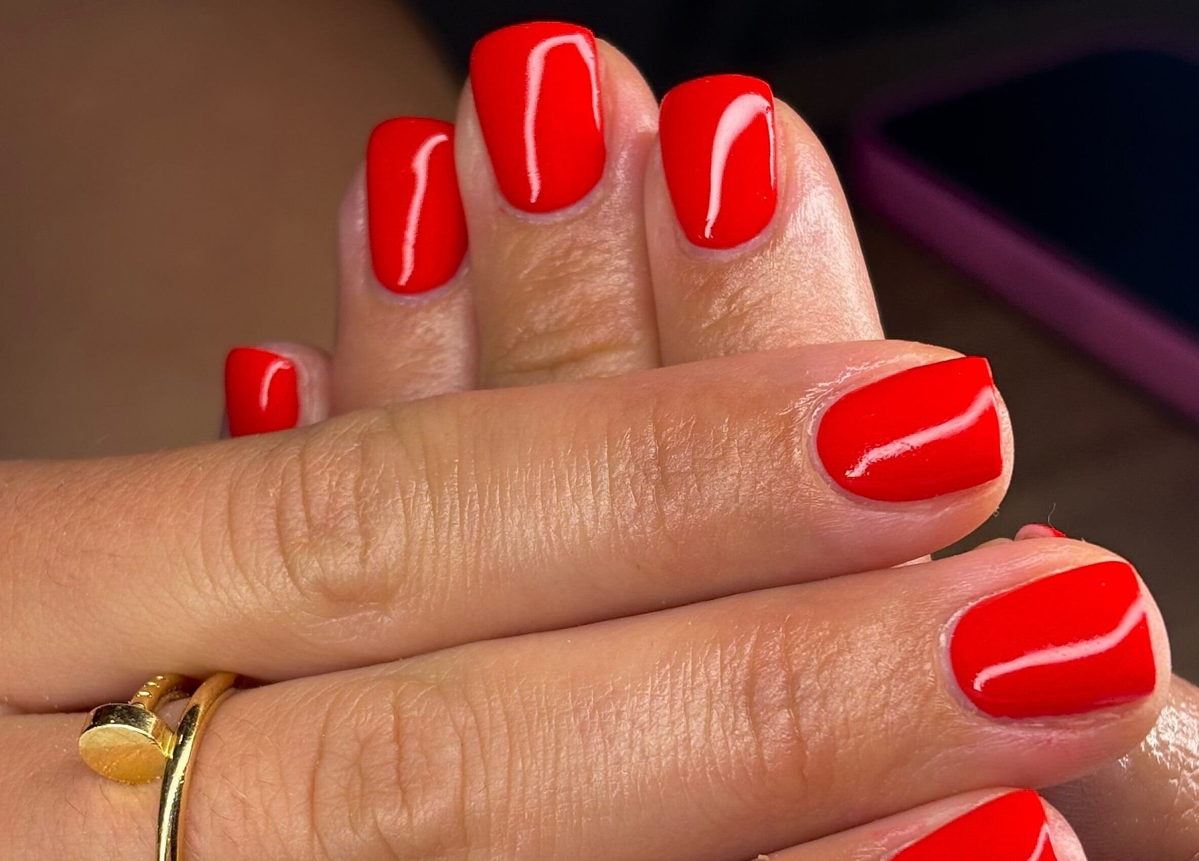 Glossy red manicure at AmiRoseBeauté in Barrington, England, GB showcases elegant nail art.