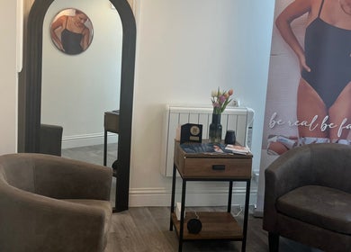 Cozy seating area at Niymimi Aesthetics, London, England, GB showcasing modern decor and promotional banner.