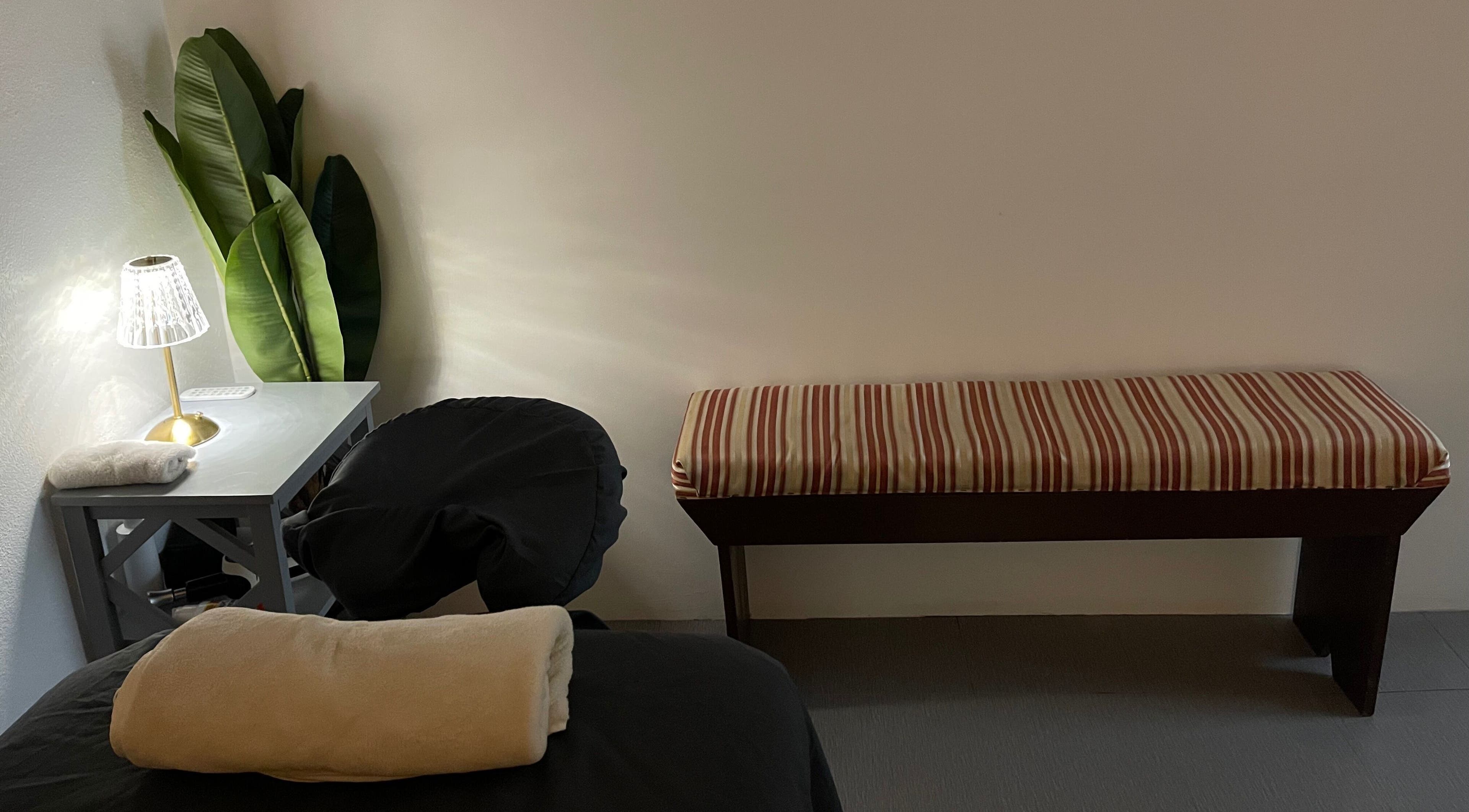 Peaceful massage space at Kaizen Massage Studio, Stella, Rincón, PR, featuring a cozy bench and ambient lighting.