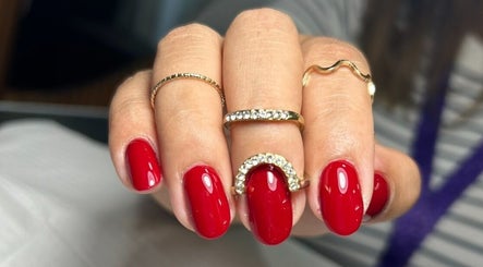 Uñas esmaltadas en rojo vibrante con anillos en Takesshy Beauty, Madrid, Comunidad De Madrid, ES.