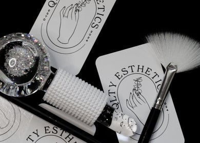 QLTY ESTHETICS beauty tools with logo, Nanaimo, British Columbia, CA, featuring brushes and glitter globe.