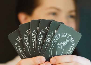 Hand holding QLTY ESTHETICS cards in Nanaimo, British Columbia, CA.